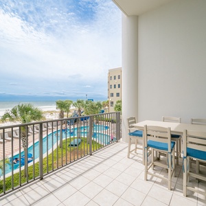 Take in the amazing views from this balcony with a dining table, overlooking the pool and beautiful beach just steps away