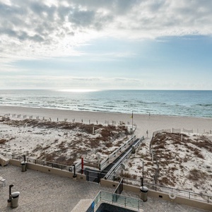 Enjoy the outdoor seating area with umbrellas, perfect for relaxing while taking in the tranquil beach views