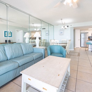 Relax on the soft leather sofa while enjoying the view of the dining area and kitchen in this inviting living space
