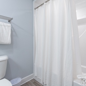 Enjoy a warm shower and neatly folded towels in this guest bath