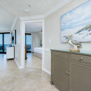 Step into a welcoming entryway featuring coastal decor and a view of the inviting living area and beach beyond
