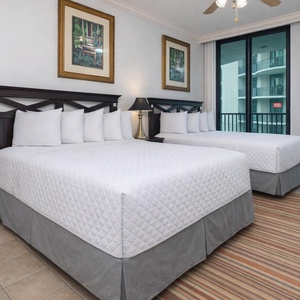 Guest bedroom featuring two plush double beds, elegant decor, and large windows for natural light