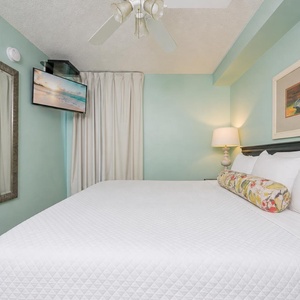Fluffy pillows invite you to relax in the king suite for a calm movie night after a fun day at the beach