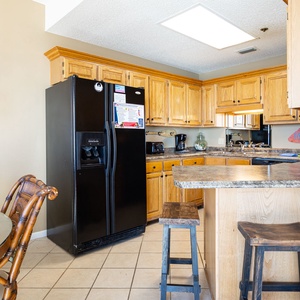 Cook and gather at this inviting kitchen with wooden cabinets, a breakfast bar, and a dining table