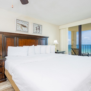 Relax in this inviting master bedroom featuring a plush king bed and a breathtaking view of the tranquil coastline