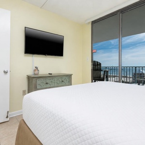 The master features a queen bed, large TV, and offers a stunning beach view from the balcony, perfect for relaxation
