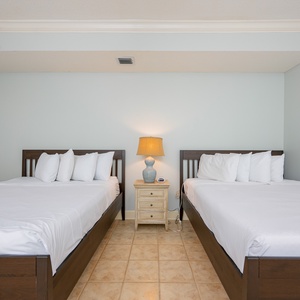 Relax in this guest room with two queens, soft bedding, and fluffy pillows for a restful retreat