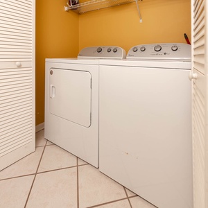 Conveniently do laundry with the washer and dryer in this cozy utility area, featuring bright yellow walls