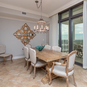 This elegant dining area features a rustic wooden table, plush chairs, and stunning views through large windows