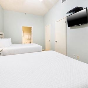 Rest comfortably in this guest room featuring double beds, soft linens, a TV, and adjoining bathroom
