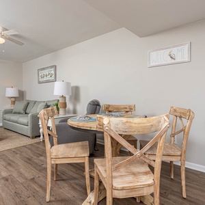 Inviting living space features cozy seating, a dining area, and a stunning view of the turquoise waters outside