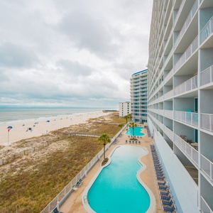 This inviting view showcases a beachfront pool area with lounge chairs, perfect for relaxation and enjoyment