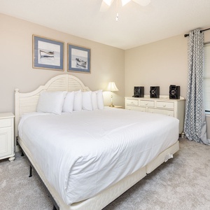 Relax in the inviting bedroom featuring a plush king bed, soft carpet, and stylish decor for a restful night's sleep