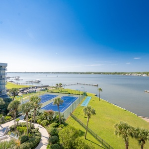 Breathtaking lagoon view with vibrant tennis courts and lush landscaping, perfect for relaxation and outdoor activities