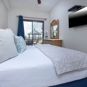 Serene master bedroom with a plush king bed, stylish decor, and direct access to the patio