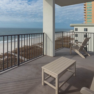 Relax on the balcony with seating and enjoy the serene view of the beach and gulf waves just steps away