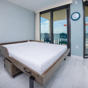 Queen murphy bed in the living area lets guests fall asleep with a glimpse of the beach from your balcony