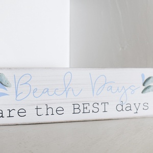 This charming decor sign captures the essence of joyful beach days, inviting guests to relax and enjoy their stay