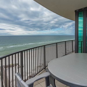 Enjoy your morning coffee at the outdoor table with sweeping views of the tranquil waters and beach below