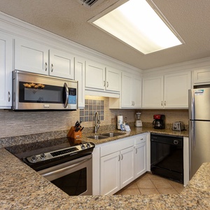 Prepare meals in the sleek kitchen featuring stainless steel appliances, ample counter space, and stylish cabinetry