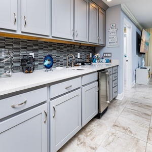 Grab a chilled drink from the fridge or create your favorite cocktail at the wet bar with charming coastal accents
