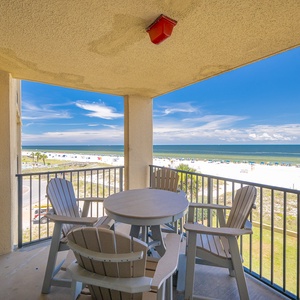 Relax on the balcony with a round table and chairs, enjoying the serene beach view and gentle gulf breeze