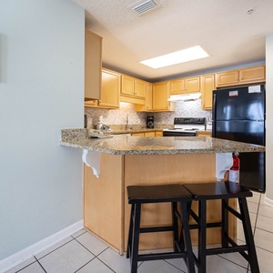 Prepare meals at the spacious kitchen island, featuring sleek countertops and black appliances for your convenience