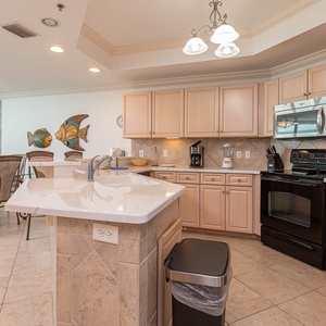Prepare meals in this inviting kitchen, featuring ample counter space and charming fish-themed decor for a delightful