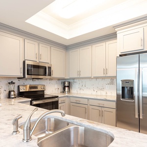 Prepare meals in this kitchen with elegant cabinetry, stainless appliances, and spacious countertops