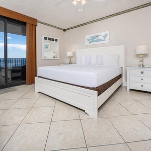 Unwind in the serene master suite featuring a comfortable king bed, stylish decor, and beachfront balcony access