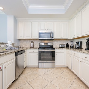 Prepare meals in this kitchen with elegant cabinetry, stainless appliances, and spacious countertops