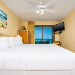 Experience restful nights in this master bedroom with a king bed and a view of the beach