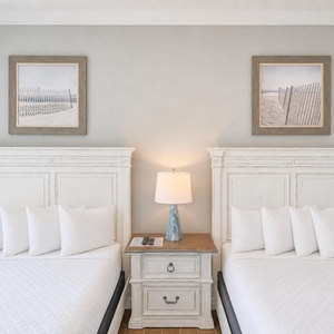 Drift to sleep on one of the plush queen beds surrounded by fluffy pillows and beach views