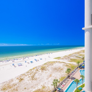 Impressive view of sunny beach and turquoise waters from the balcony, perfect for relaxing in the sun