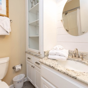 Bright and airy guest bathroom featuring a stylish mirror, granite countertop, and fresh towels for a refreshing retreat