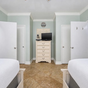 Inviting guest bedroom with two queen beds, a TV, and easy access to the stylish guest bathroom