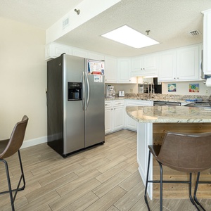 Granite counters wrap this kitchen where you can sip morning coffee at the breakfast bar before the day begins