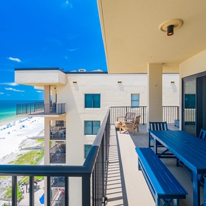 Relax on the spacious balcony with blue seating, enjoying breathtaking views of the white serene beach and turquoise waters