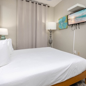 Relax in this guest bedroom featuring a queen bed, soft lighting, and colorful artwork for a peaceful retreat