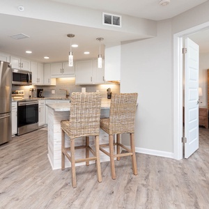 Gather around the kitchen with bar stools for casual dining, surrounded by stylish cabinetry and stainless appliances