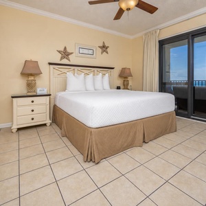 The master suite features a king bed, bedside tables, and balcony access with a view of the gulf