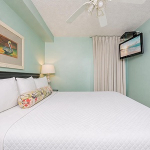 Fluffy pillows invite you to relax in the king suite for a calm movie night after a fun day at the beach