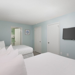 Rest in this inviting bedroom with two double beds, soft linens, and a TV during your stay