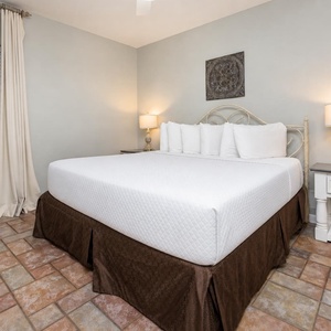 Unwind in this serene bedroom featuring a plush king bed, soft lighting, and inviting decor for a restful stay