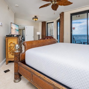 Find comfort in this spacious master bedroom with a king bed, elegant decor, and beautiful beachfront views
