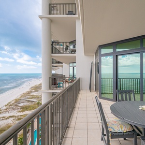 Spacious balcony with inviting seating offers breathtaking views of the pristine beach and tranquil waters beyond