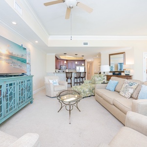 Cozy living room featuring a large TV, comfy seating, and a stylish turquoise cabinet for a welcoming atmosphere