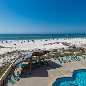 Experience relaxation by the sparkling pool with a breathtaking beach view and lounge chairs for sunbathing
