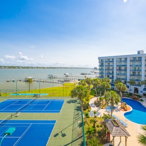Enjoy a scenic view of tennis courts and the lagoon while relaxing on your cozy private balcony
