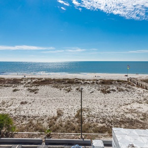 This view showcases a serene beachfront with soft sands and gentle waves, perfect for relaxation and enjoyment